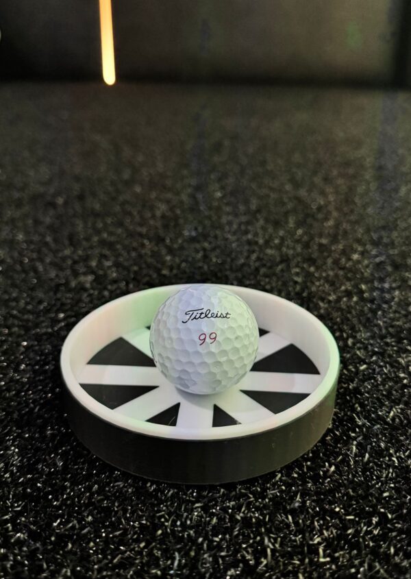 Golf putting cup reducer installed in artificial turf putting green with Titleist ball showing training aid in practice position