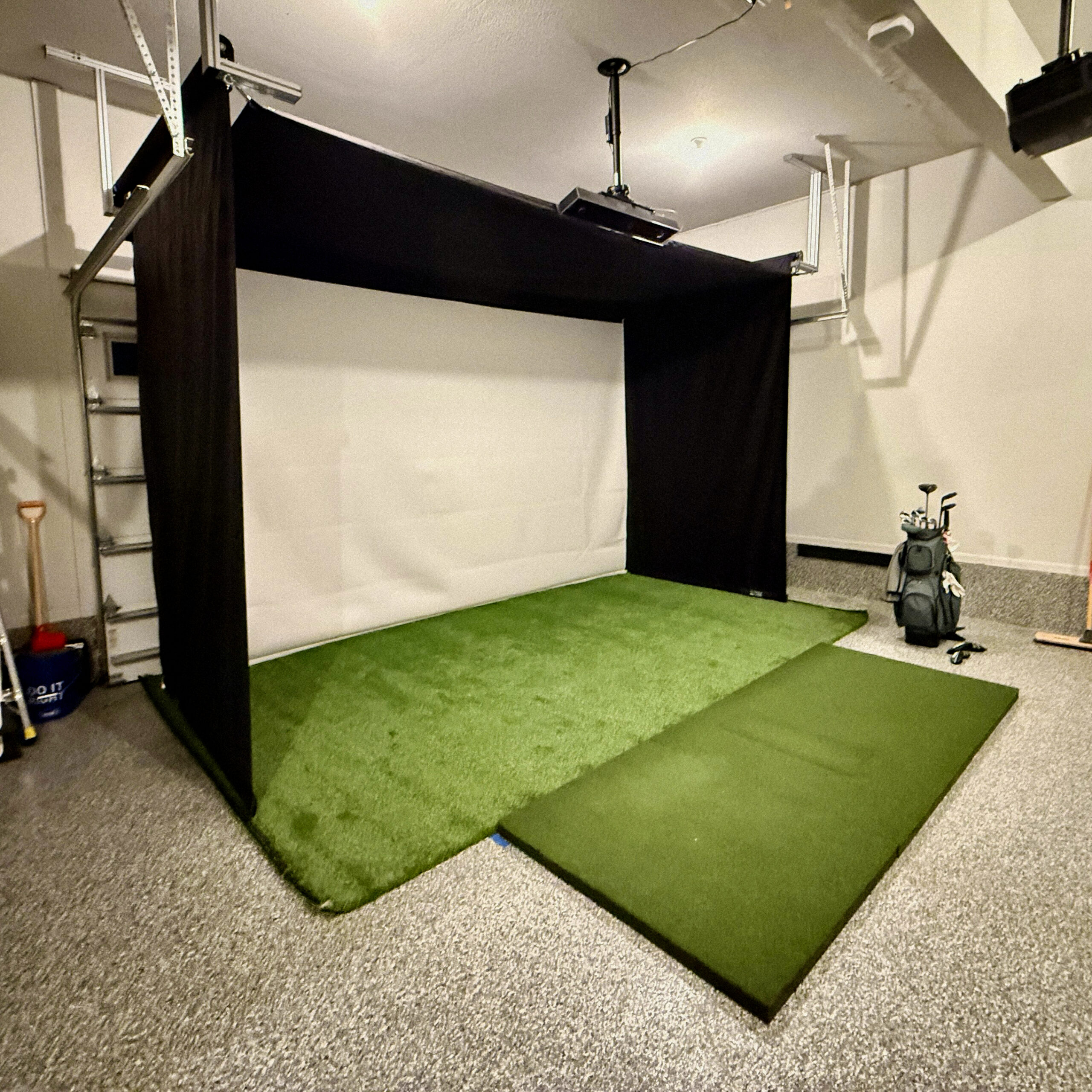 SportScreen Vanish 16 retractable golf simulator enclosure deployed in a garage