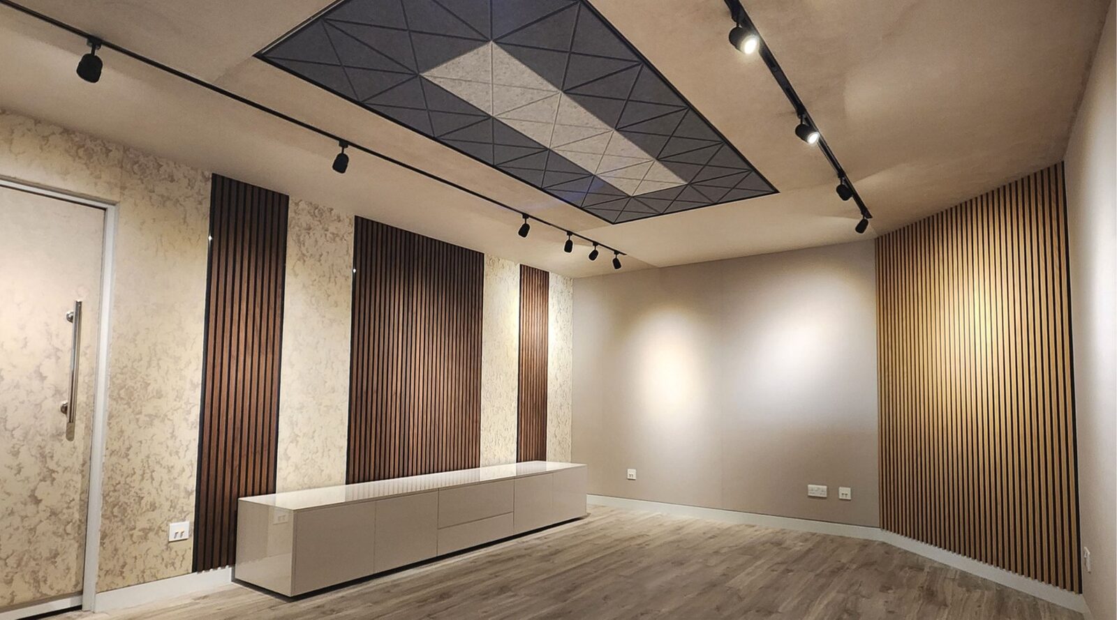 Wood slatted acoustic wall panels installed in a media room with acoustic ceiling tiles