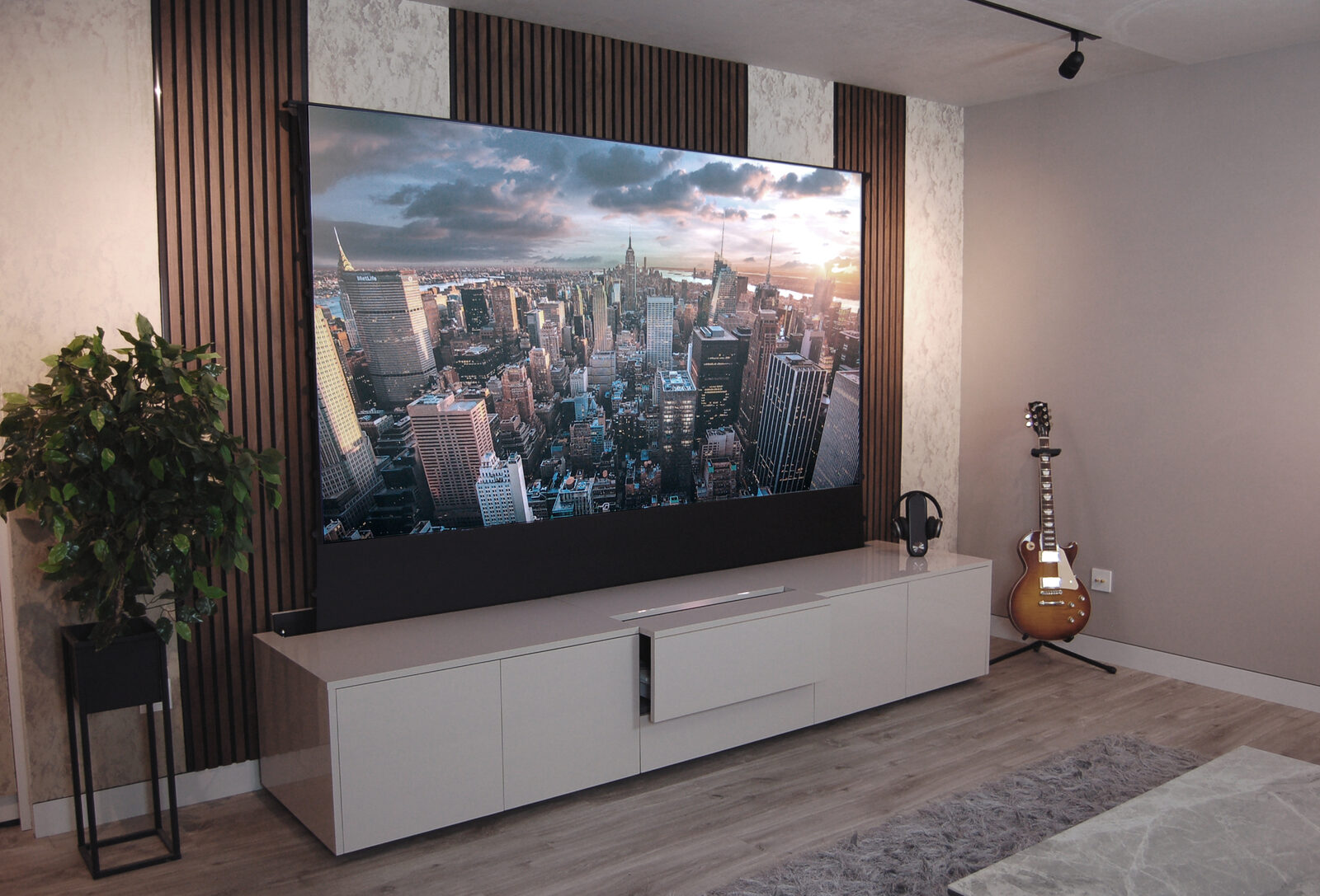 Walnut wood slatted acoustic panels fitted as a TV feature wall in a home cinema room